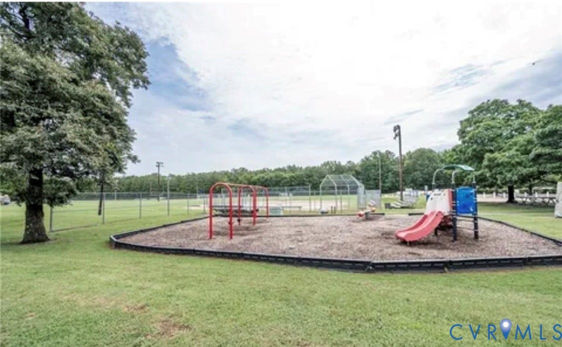 10211 Wolfe Manor Court, #711, Glen Allen, VA 23060 Recreational area featuring a playground with slides and swings, wood-chip ground cover, manicured lawn, perimeter fencing, and mature trees