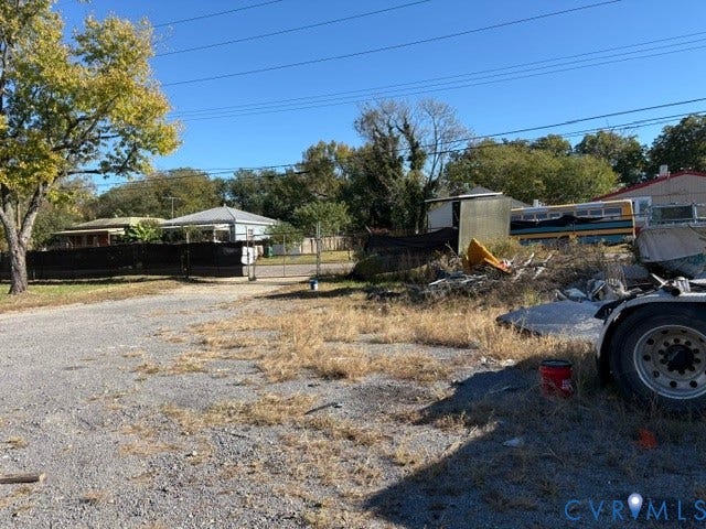 1143 McKenzie Street, Petersburg, VA 23803 Gravel lot featuring mature trees and a chain-link perimeter fence