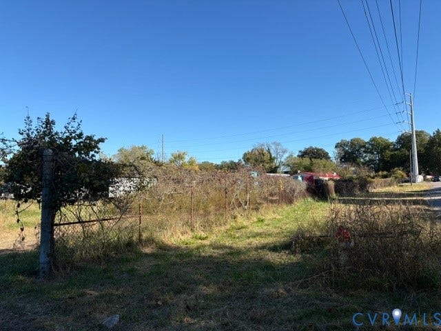 1143 McKenzie Street, Petersburg, VA 23803 Expansive unimproved lot featuring chain-link fencing, mature trees, and street-level utility access