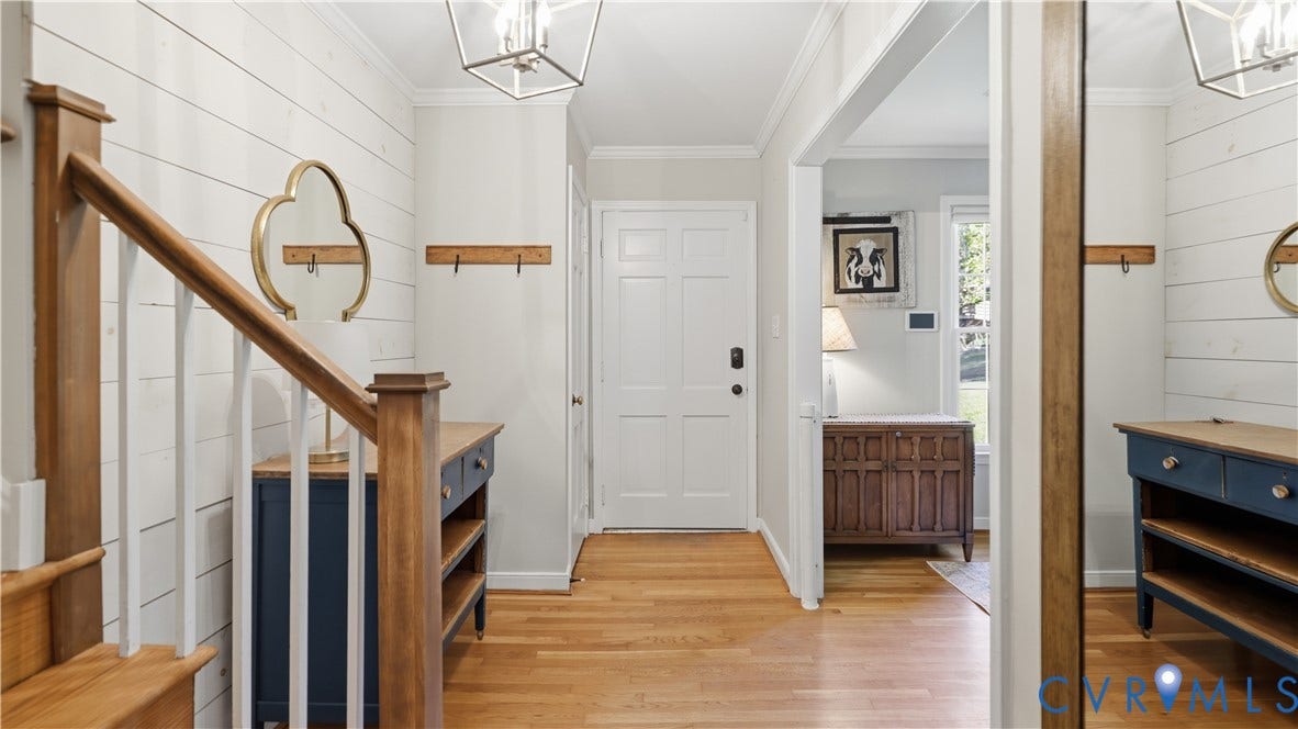 10010 Cheyenne Court, Richmond, VA 23235 Entryway featuring horizontal plank wall detailing, wood-finish flooring, a wood-accented staircase, and geometric hanging light fixtures
