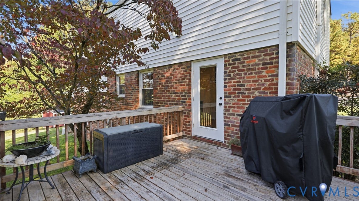 10010 Cheyenne Court, Richmond, VA 23235 Exterior wood deck with a traditional railing, multi-toned brick masonry, white horizontal siding, and a glass-paneled entry door