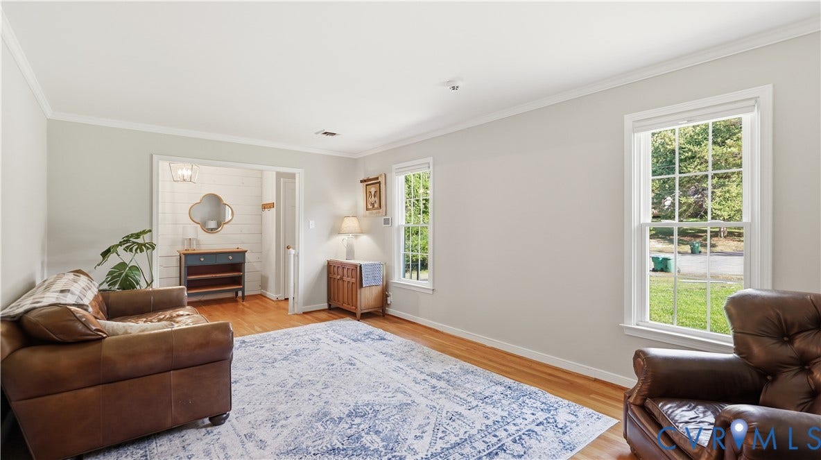 10010 Cheyenne Court, Richmond, VA 23235 Living area featuring wood-finish flooring, crown molding, multi-pane windows, and white-paneled accent wall detail