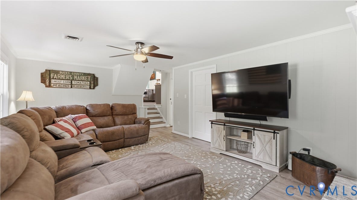 10010 Cheyenne Court, Richmond, VA 23235 Living area featuring light-toned wood-finish flooring, a ceiling fan with integrated lighting, and a six-panel interior door