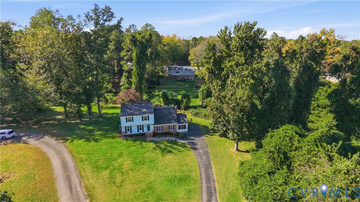 10010 Cheyenne Court, Richmond, VA 23235 Two-story residence featuring light-colored siding, a mixed brick facade, a shingled roof, a paved driveway, and established trees on a spacious lot
