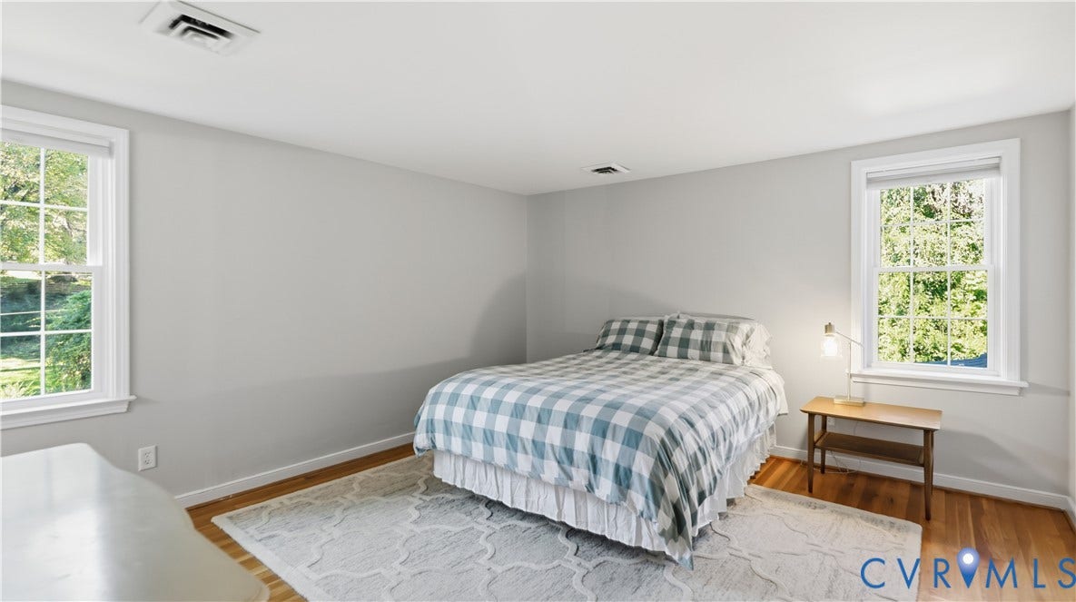 10010 Cheyenne Court, Richmond, VA 23235 Neutral-toned interior room featuring wood-finish flooring and dual double-hung windows with exterior grid detailing
