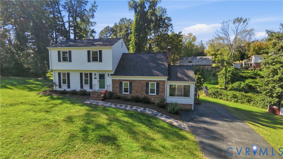 10010 Cheyenne Court, Richmond, VA 23235 Two-story residence featuring white horizontal siding, a red brick veneer lower level, asphalt shingle roof, flagstone walkway, and an asphalt driveway