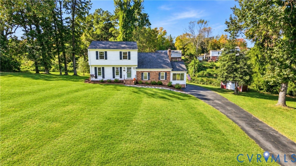 10010 Cheyenne Court, Richmond, VA 23235 Two-story exterior featuring a brick and white siding facade, asphalt shingle roof, dark window shutters, expansive green lawn, and paved driveway