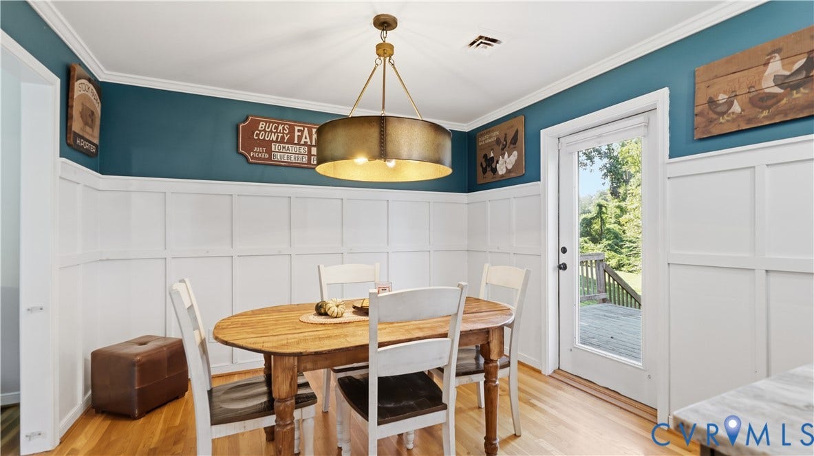 10010 Cheyenne Court, Richmond, VA 23235 Dining area featuring wood-finish flooring, white board-and-batten wainscoting, a cylindrical metal pendant light, and a glass-paneled exterior door