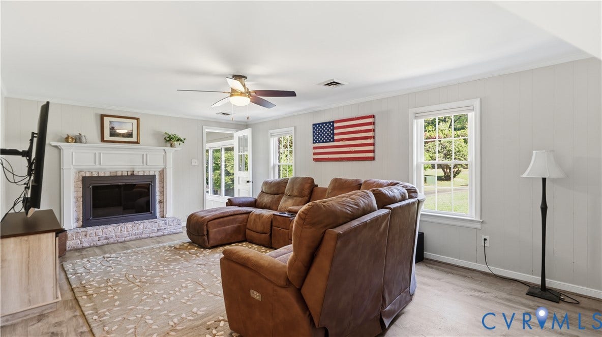 10010 Cheyenne Court, Richmond, VA 23235 Living area featuring light wood-finish flooring, a brick fireplace with a decorative mantel, and a ceiling fan