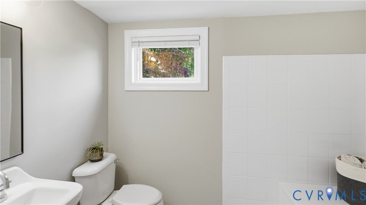 10010 Cheyenne Court, Richmond, VA 23235 Wall-mounted mirror, pedestal sink with metal hardware, and white ceramic tile shower surround