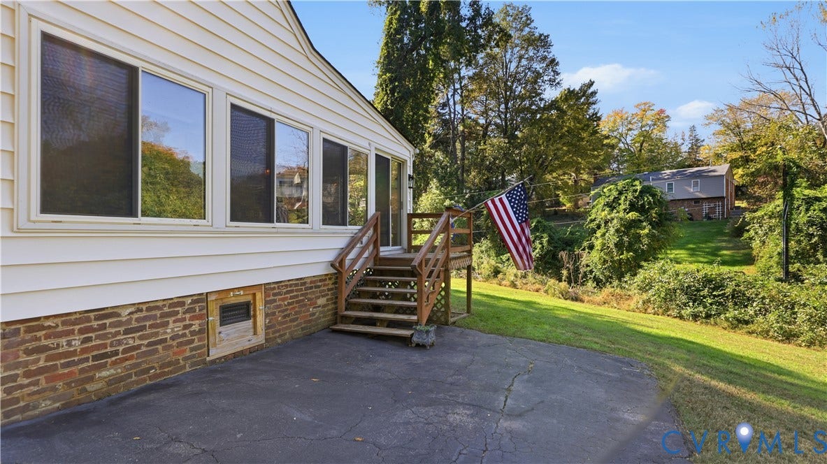 10010 Cheyenne Court, Richmond, VA 23235 Exterior featuring horizontal siding, a red brick foundation base, a paved patio, and a raised wooden deck with stairs