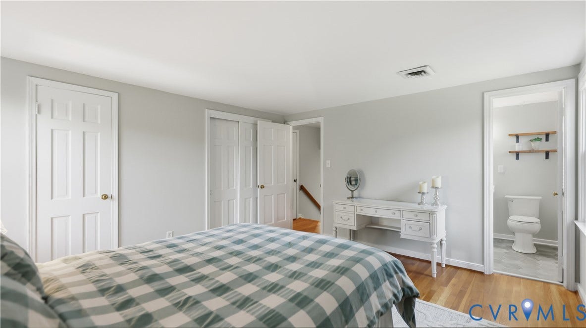 10010 Cheyenne Court, Richmond, VA 23235 Bedroom featuring wood-finish flooring, multi-panel doors, bi-fold closet doors, and an attached bathroom with wall-mounted shelving