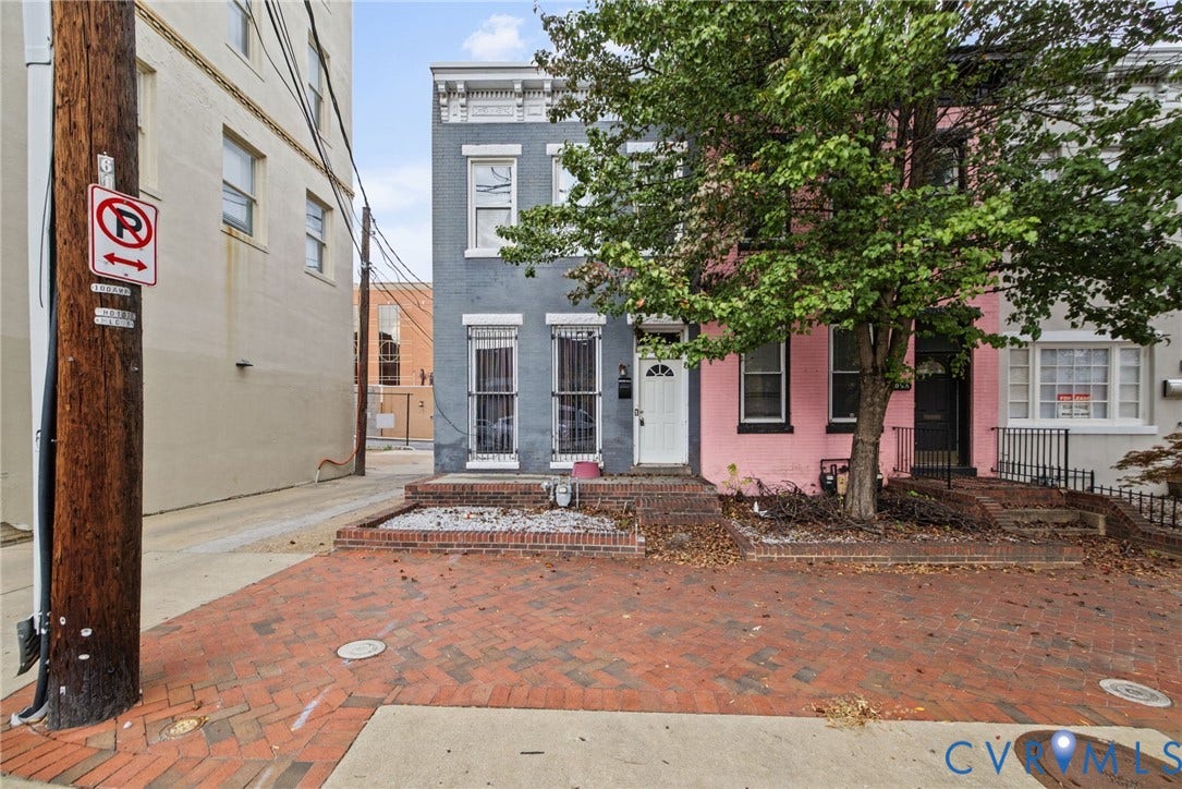 510 N 3rd Street, Jackson Ward, Richmond, VA 23219 Two-story masonry townhouse exterior featuring a painted brick facade, raised brick-edged masonry planter beds, and decorative window lintels