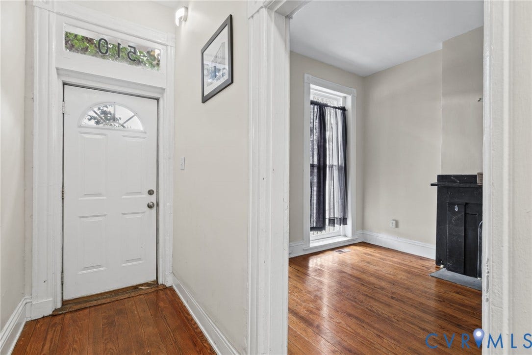 510 N 3rd Street, Jackson Ward, Richmond, VA 23219 Entryway featuring a white door with a glass transom, wood-finish flooring, and a decorative fireplace surround