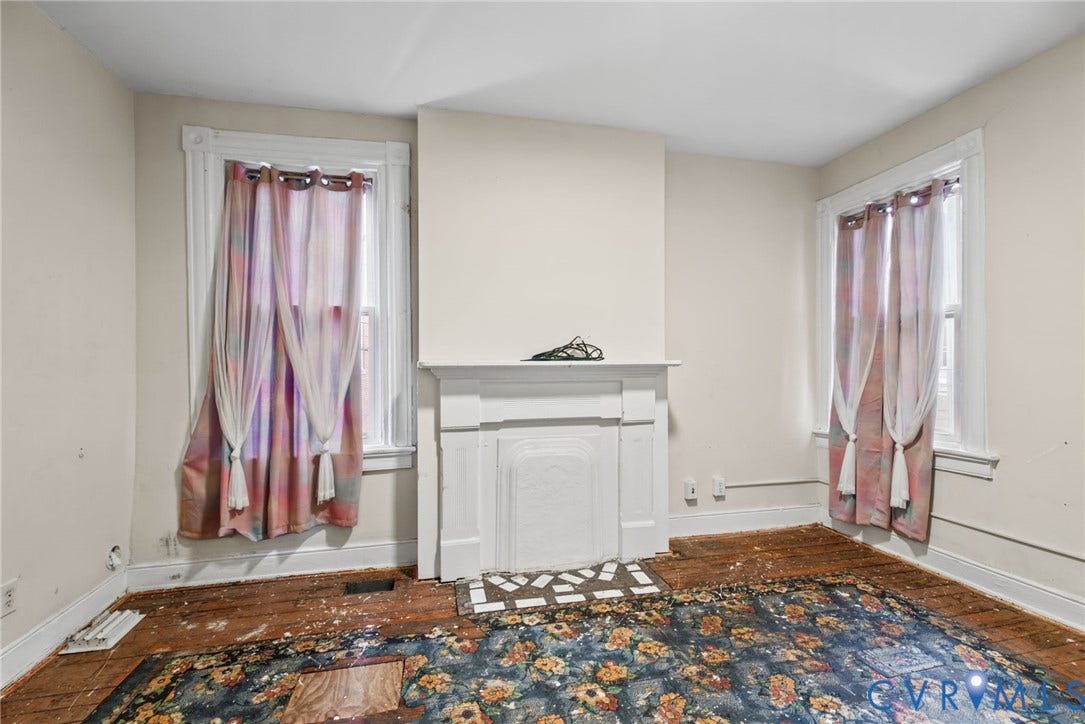 510 N 3rd Street, Jackson Ward, Richmond, VA 23219 Bedroom 2 - Room featuring original wood flooring, a central decorative fireplace with a mantel, and two windows with molded trim