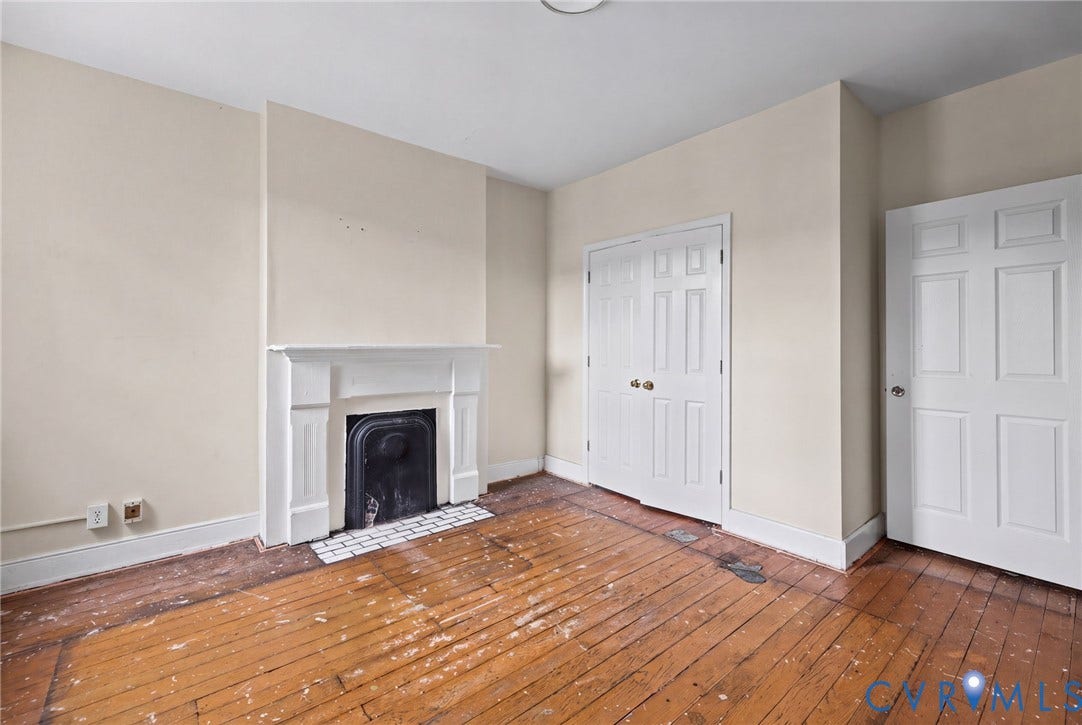 510 N 3rd Street, Jackson Ward, Richmond, VA 23219 Bedroom 1 - Hardwood flooring, wood-burning fireplace with a mantel, and paneled closet doors