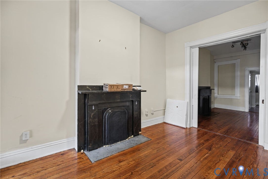 510 N 3rd Street, Jackson Ward, Richmond, VA 23219 Dark stone fireplace surround with a matching hearth, wood-finish flooring, and high-profile architectural door casing