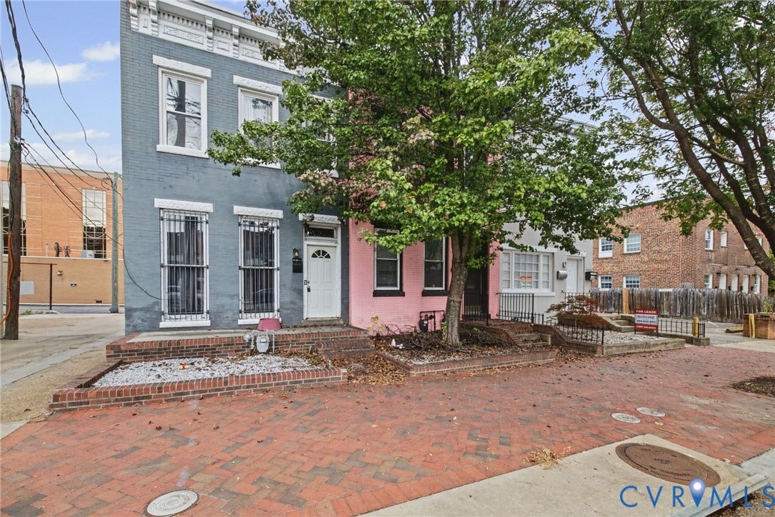 510 N 3rd Street, Jackson Ward, Richmond, VA 23219 Multi-story masonry exterior featuring a painted brick facade, raised brick planter beds, and decorative window security bars
