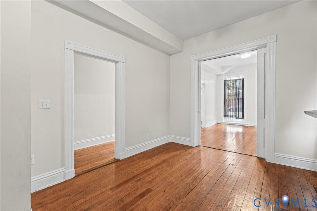 510 N 3rd Street, Jackson Ward, Richmond, VA 23219 Interior space featuring polished wood-finish flooring, high-profile white door casing, and sliding pocket doors