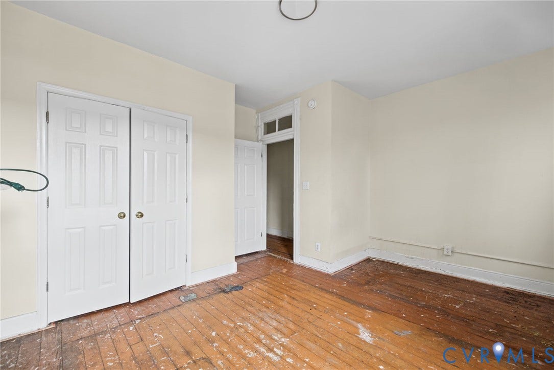 510 N 3rd Street, Jackson Ward, Richmond, VA 23219 Bedroom 1 - Hardwood flooring, paneled closet doors, and a decorative transom window above the doorway