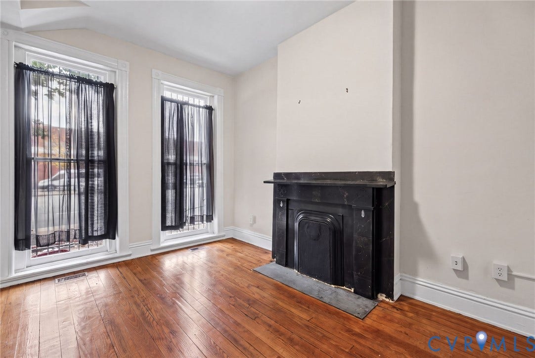 510 N 3rd Street, Jackson Ward, Richmond, VA 23219 Bedroom 1 -Interior space featuring wood-finish flooring, high ceilings, dual tall windows, and a decorative fireplace with a stone mantel