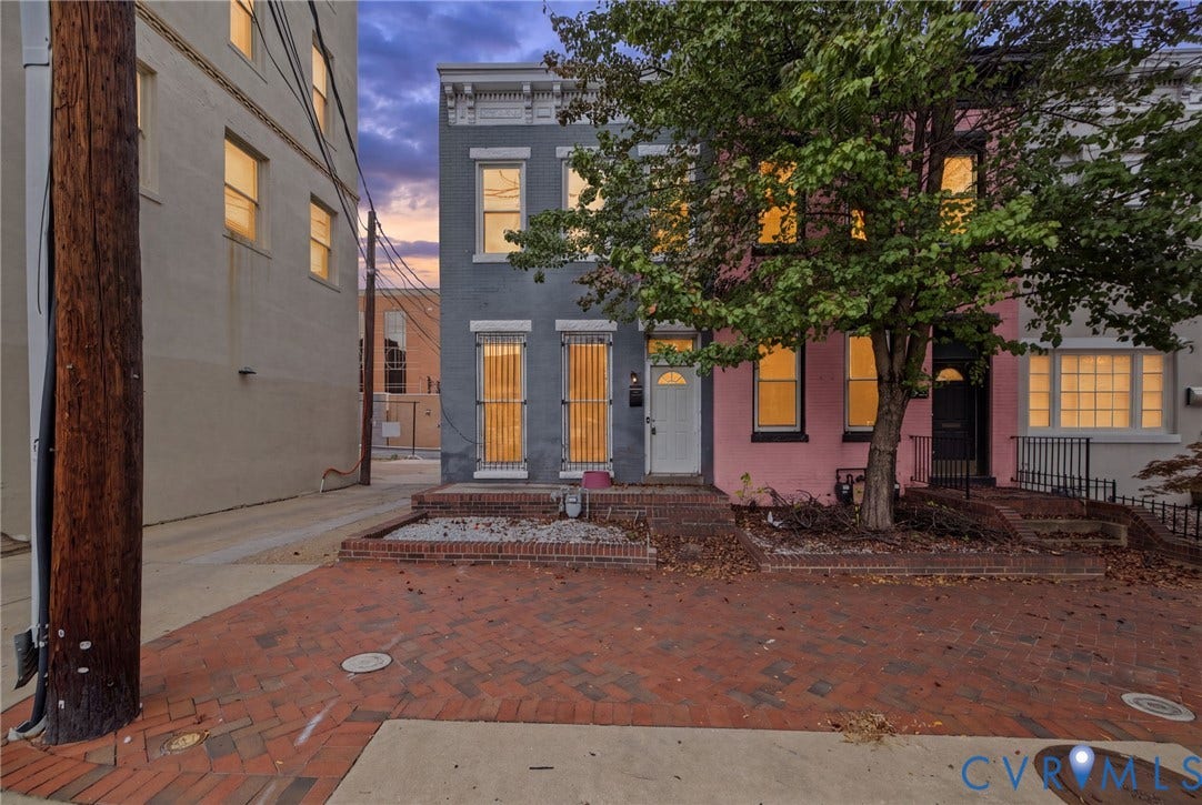 510 N 3rd Street, Jackson Ward, Richmond, VA 23219 Multi-story masonry exterior featuring vertical pane windows, decorative lintels, and a brick-paved front terrace with integrated planter beds