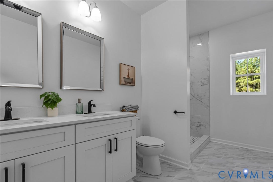 19614 Manson Church Road, Mc Kenney, VA 23872 Double vanity featuring white cabinetry, quartz countertops, matte black fixtures, and rectangular mirrors, complemented by a walk-in shower with tile surround and stone-patterned floor tile