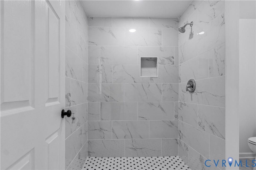 19614 Manson Church Road, Mc Kenney, VA 23872 Walk-in shower featuring large-format stone-patterned wall tile, white penny tile flooring, integrated wall niche, and polished chrome shower fixtures