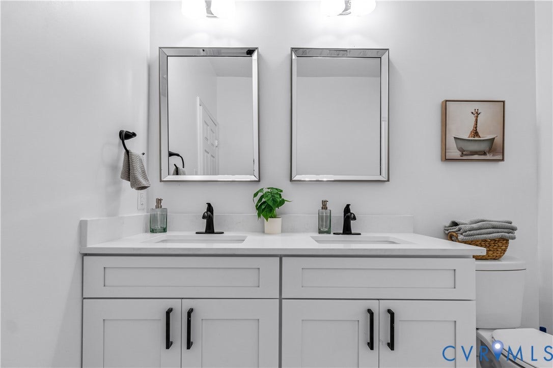 19614 Manson Church Road, Mc Kenney, VA 23872 Dual-sink vanity with white shaker-style cabinetry, matte black hardware, stone-surface countertop, and two framed wall-mounted mirrors
