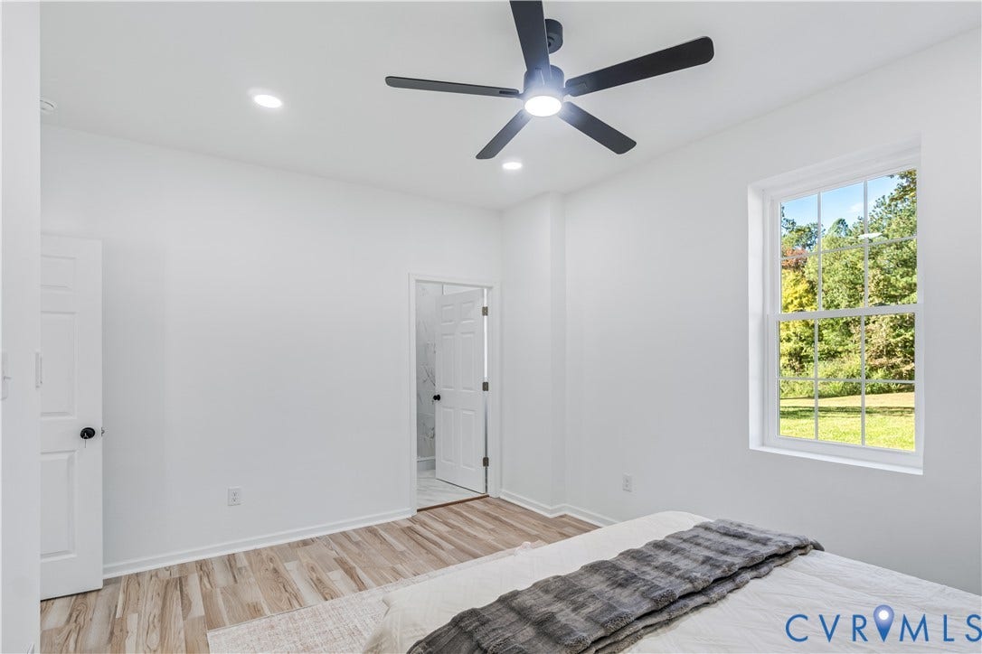 19614 Manson Church Road, Mc Kenney, VA 23872 Neutral wall palette, wood-finish flooring, recessed lighting, matte black ceiling fan, and multi-pane window