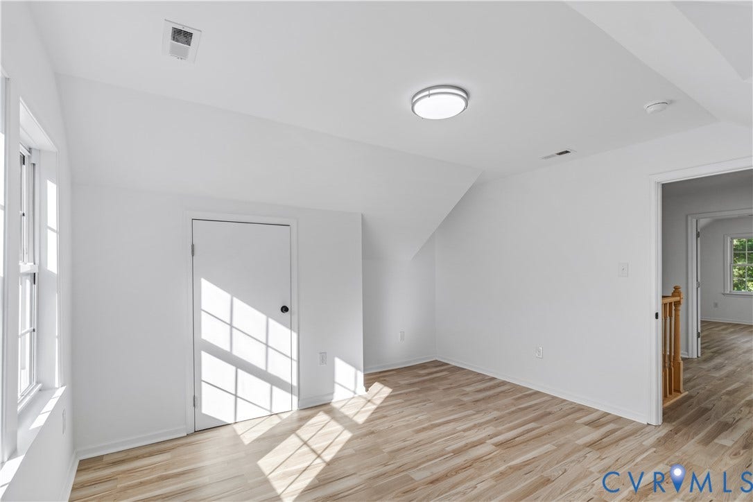 19614 Manson Church Road, Mc Kenney, VA 23872 Neutral-toned room featuring sloped ceilings, wood-finish flooring, a flush-mount circular light fixture, and a single-panel interior door