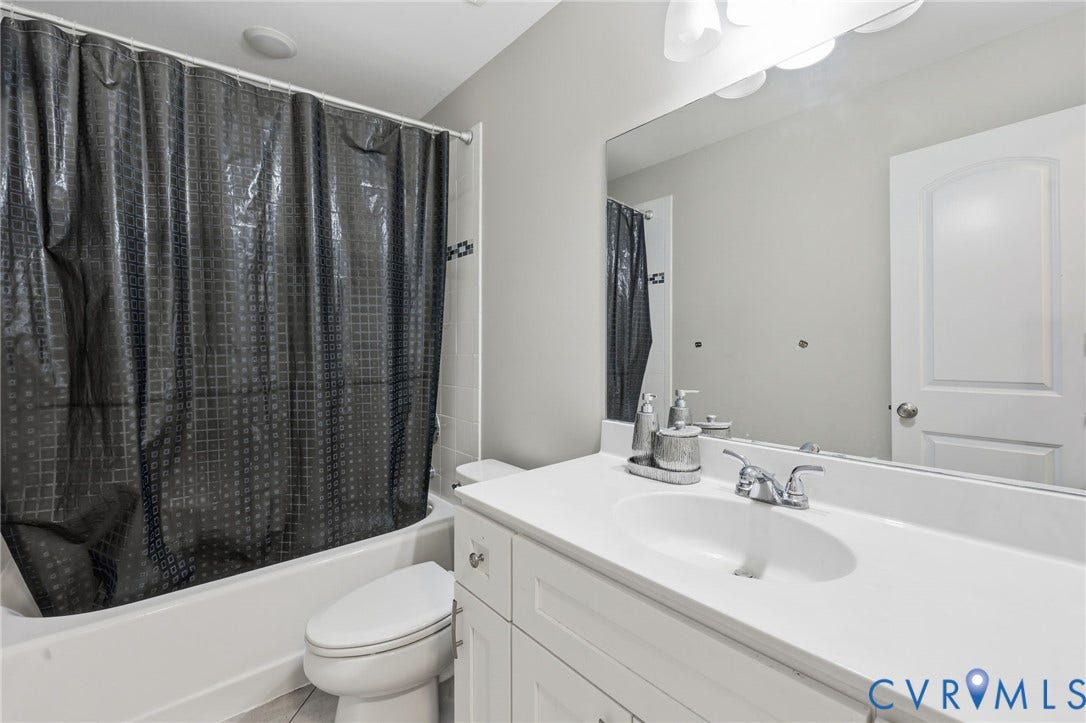 6614 Gills Gate Drive, Chesterfield, VA 23832 Bathroom featuring a white vanity with a composite countertop and integrated sink, a large wall-mounted mirror, a tub-shower combination, and polished chrome fixtures