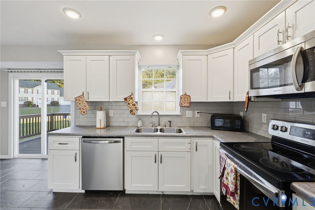 6614 Gills Gate Drive, Chesterfield, VA 23832 Kitchen featuring white shaker-style cabinetry, stainless steel appliances, subway tile backsplash, stone-finish countertops, and large-format floor tile