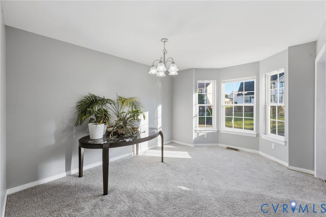 6614 Gills Gate Drive, Chesterfield, VA 23832 Neutral-toned interior featuring a bay window with triple-pane glazing, wall-to-wall carpeting, and a five-arm multi-light chandelier
