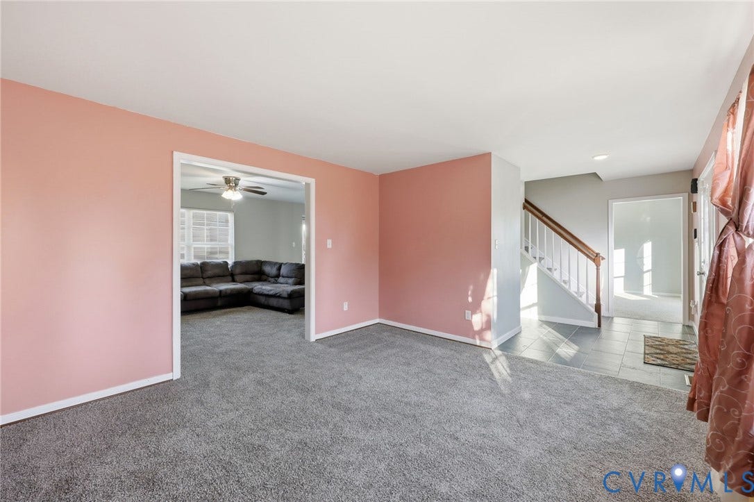 6614 Gills Gate Drive, Chesterfield, VA 23832 Interior room featuring wall-to-wall carpeting, painted walls, tile flooring in the entry area, and a staircase with a wooden handrail and balusters