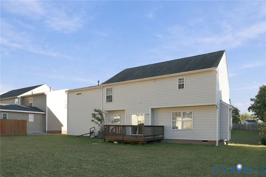 6614 Gills Gate Drive, Chesterfield, VA 23832 Two-story exterior featuring light-colored horizontal siding, a pitched shingle roof, a raised wooden deck, and a spacious backyard