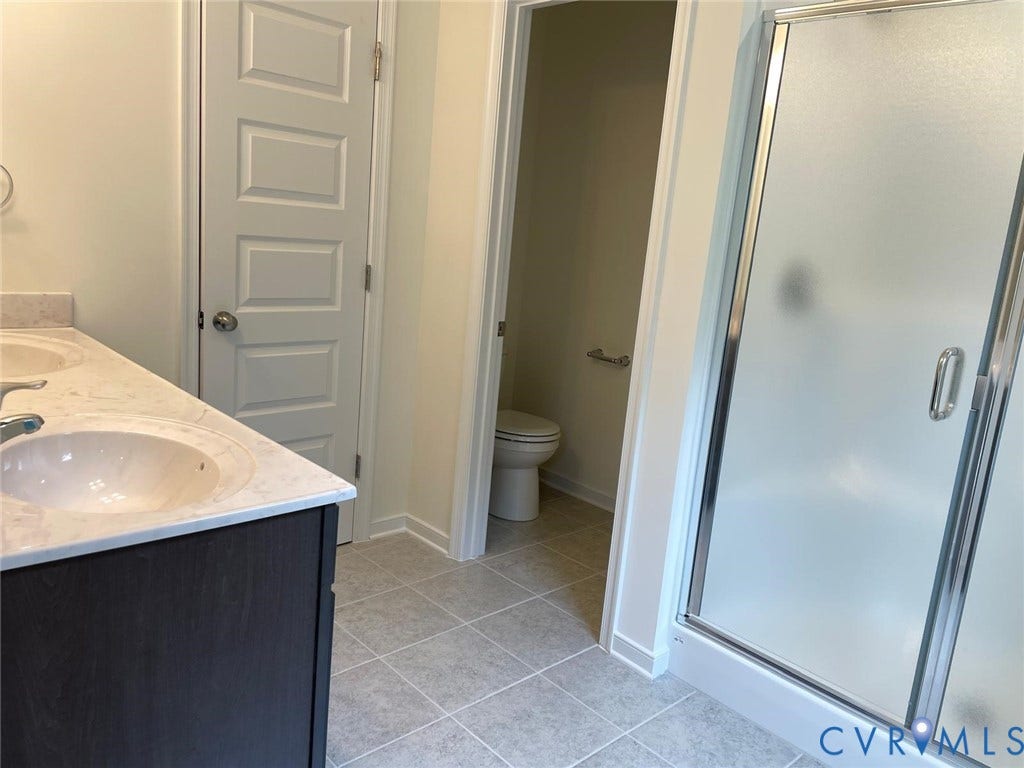 10823 Farmstead Mill Drive, Henrico, VA 23059 Bathroom featuring tile patterned floors, toilet, a shower with door, and vanity