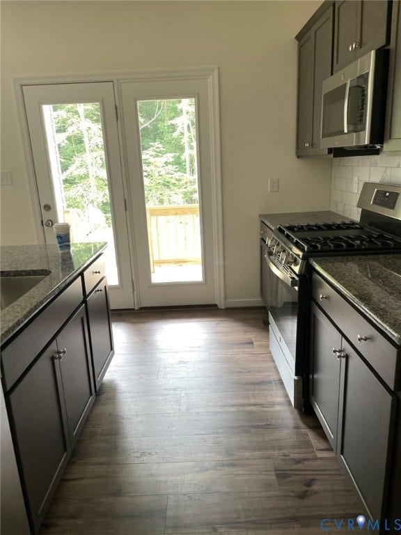10823 Farmstead Mill Drive, Henrico, VA 23059 Kitchen featuring appliances with stainless steel finishes, backsplash, dark hardwood / wood-style flooring, and a healthy amount of sunlight