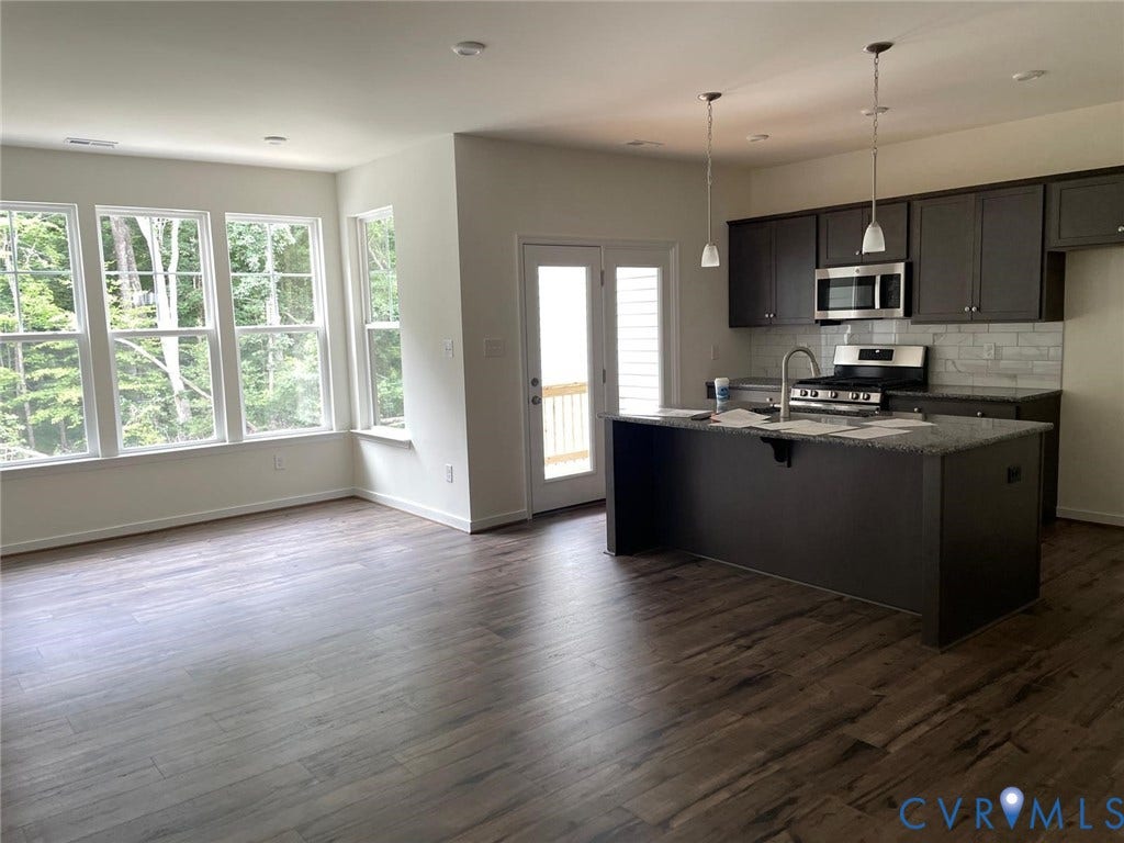 10823 Farmstead Mill Drive, Henrico, VA 23059 Kitchen with backsplash, dark hardwood / wood-style floors, a kitchen island with sink, appliances with stainless steel finishes, and dark stone countertops