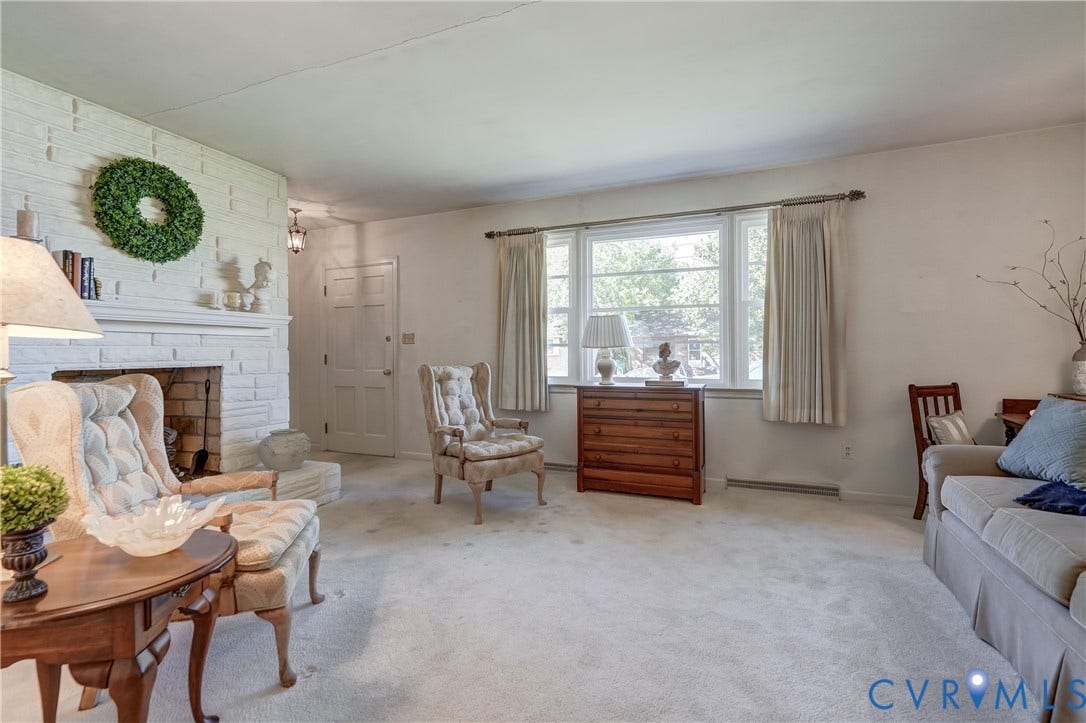409 Lilliston Avenue, Colonial Heights, VA 23834 Living area featuring a painted brick fireplace with a detailed mantel and a large window with natural light