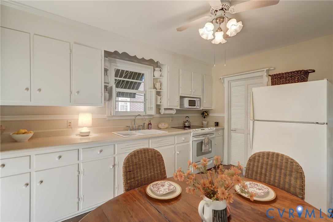 409 Lilliston Avenue, Colonial Heights, VA 23834 Kitchen featuring white shaker-style cabinetry, solid-surface countertops, dual-basin sink, overhead ceiling fan with light fixture, and louvered door closet