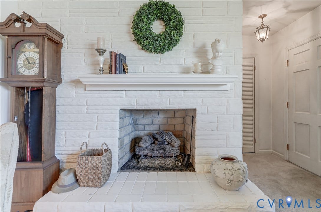 409 Lilliston Avenue, Colonial Heights, VA 23834 White painted brick fireplace featuring a classic mantel, a masonry hearth, and a pendant light fixture