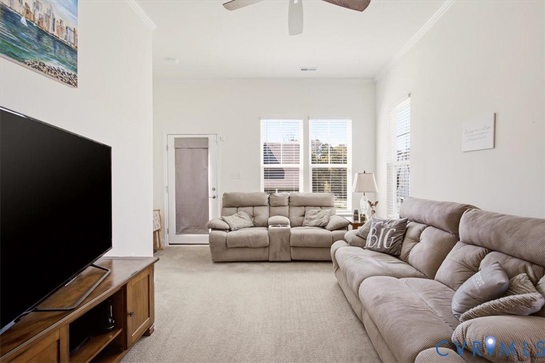 18743 Palisades Ridge, Palisades Cove, Moseley, VA 23120 High ceilings with a central ceiling fan, neutral carpeting, and abundant natural light from multiple windows and a glass-paneled exterior door