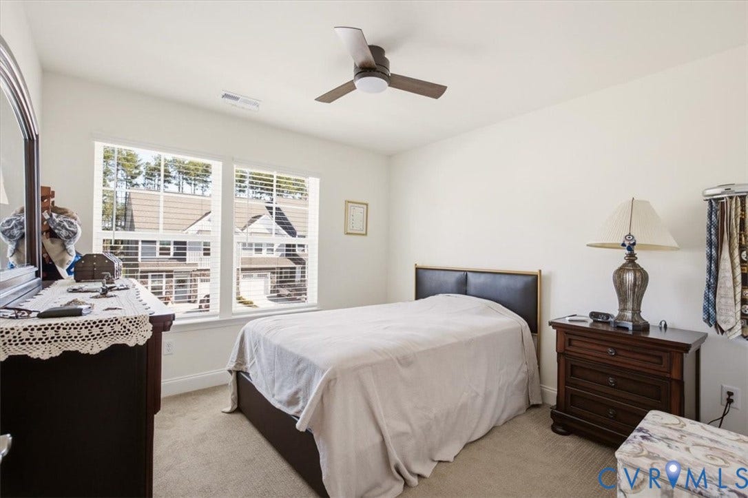 18743 Palisades Ridge, Palisades Cove, Moseley, VA 23120 Neutral-toned carpeted flooring, dual-pane windows with horizontal blinds, and a three-blade ceiling fan with integrated lighting