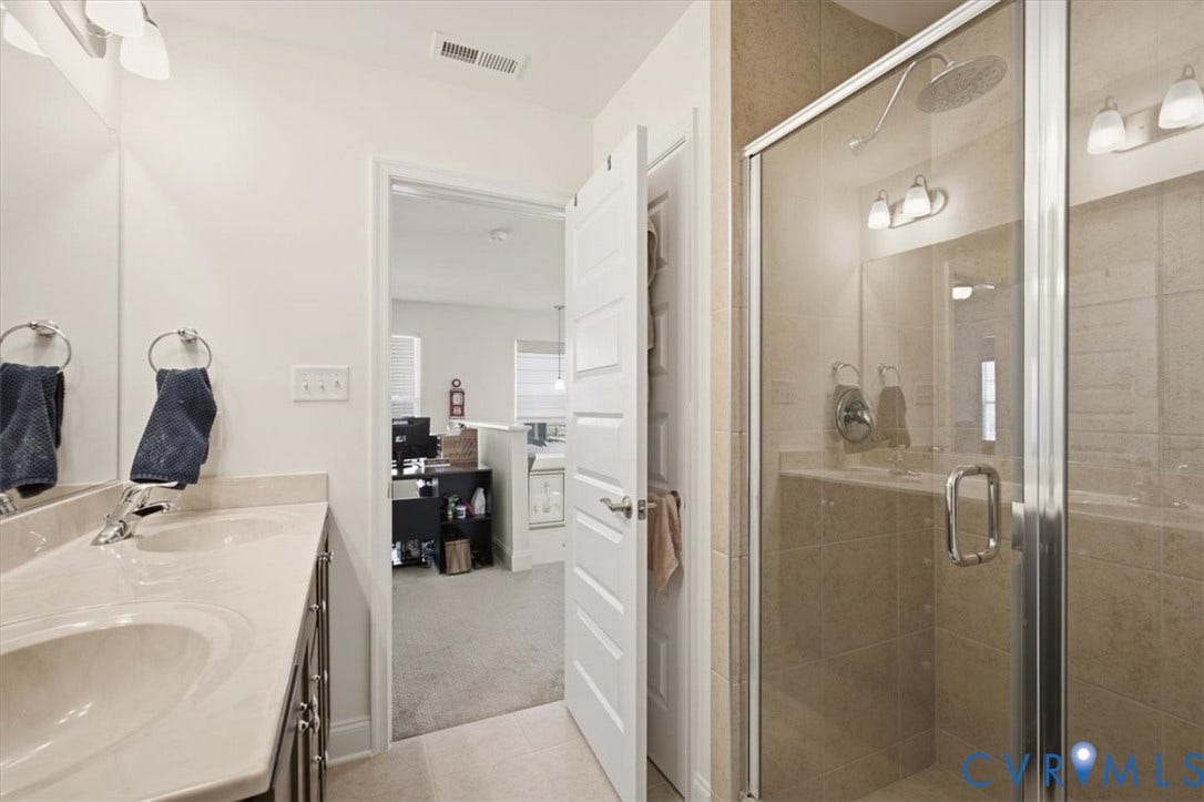 18743 Palisades Ridge, Palisades Cove, Moseley, VA 23120 Bathroom featuring a dual-sink vanity with a stone-surface countertop, a glass-enclosed walk-in shower with tile surround, and an integrated lighting fixture