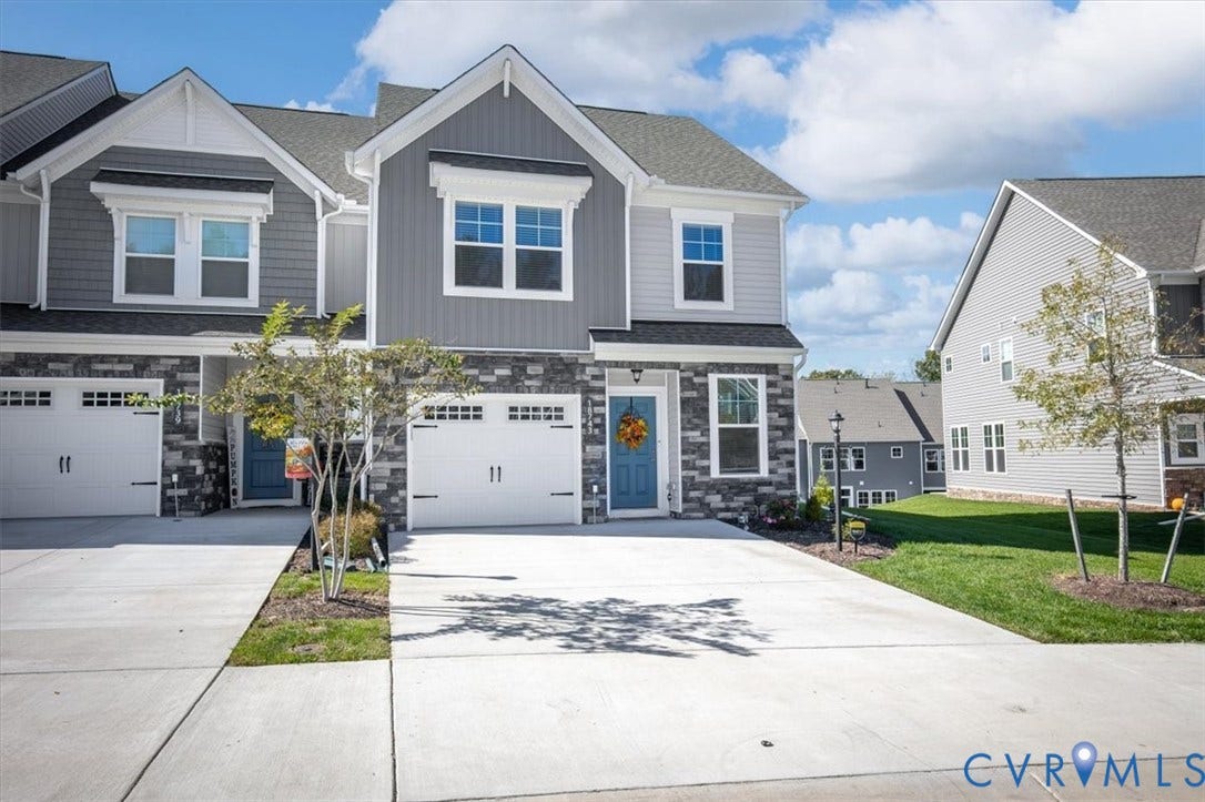 18743 Palisades Ridge, Palisades Cove, Moseley, VA 23120 Multi-level exterior featuring stone veneer siding, vertical and horizontal paneling, shingle roofing, and attached two-car garages with concrete driveways