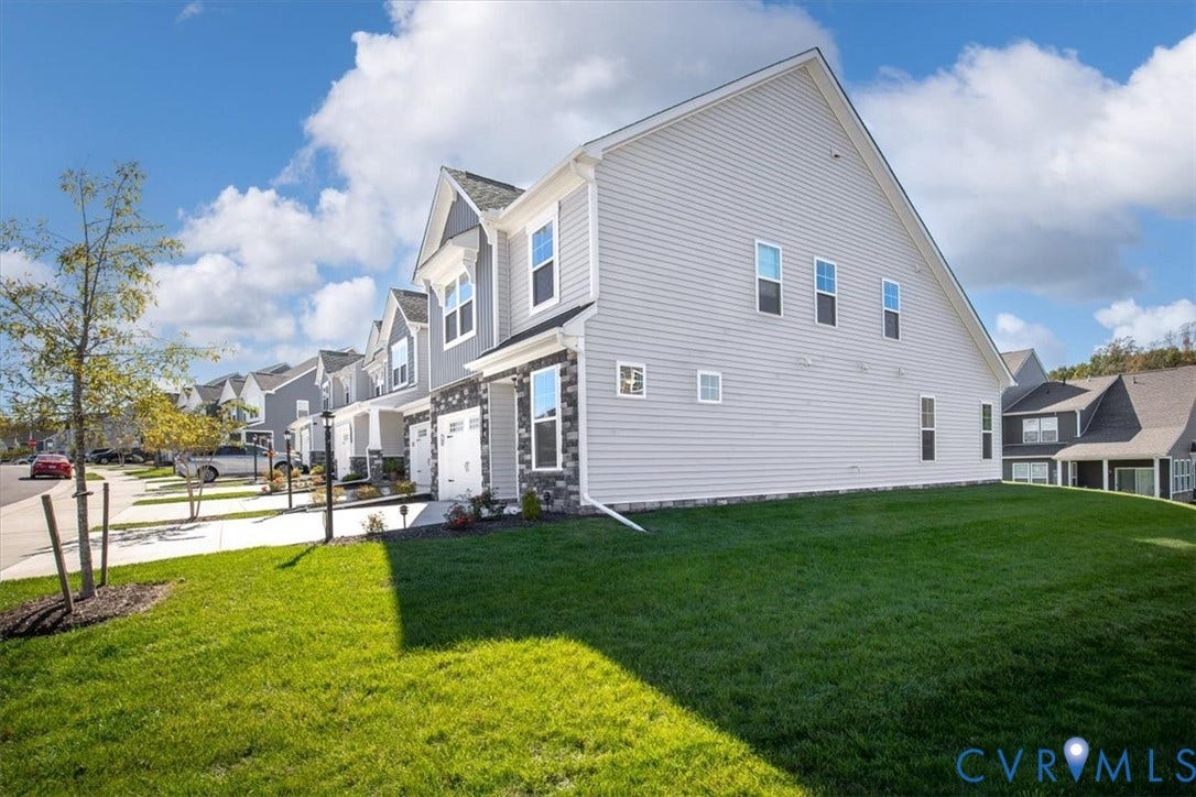 18743 Palisades Ridge, Palisades Cove, Moseley, VA 23120 Two-story residence featuring light-toned horizontal siding, a partial stone veneer facade, a shingled roof, and a concrete driveway