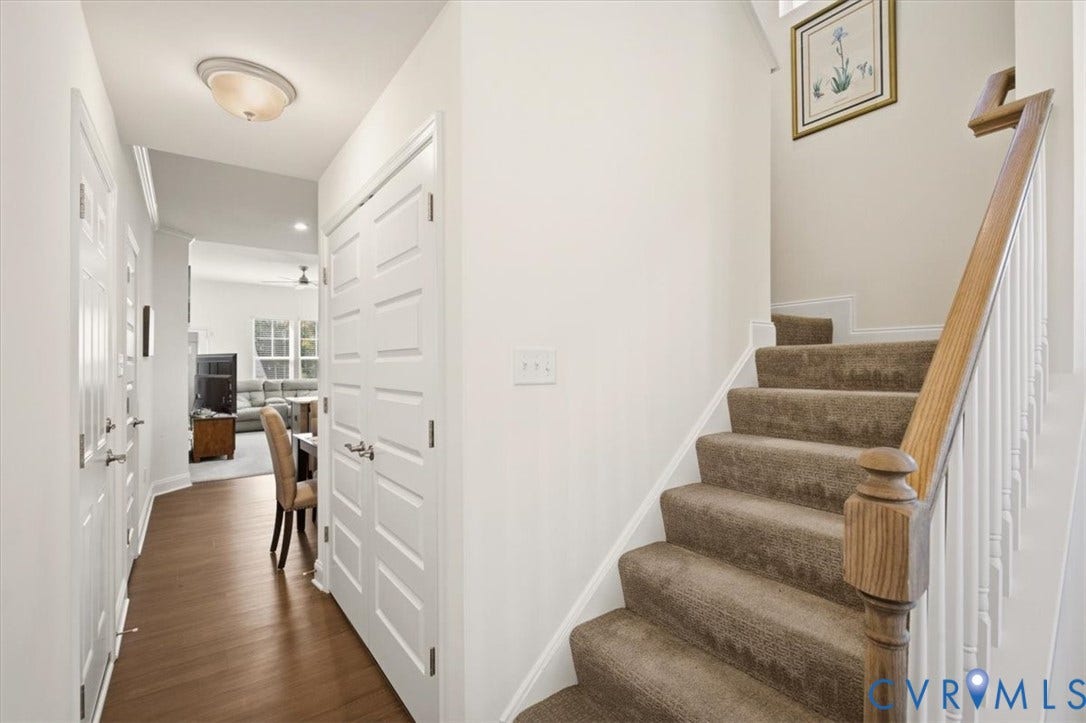 18743 Palisades Ridge, Palisades Cove, Moseley, VA 23120 Entryway featuring wood-finish flooring, a double-door closet, and a staircase with a wooden handrail and white balusters