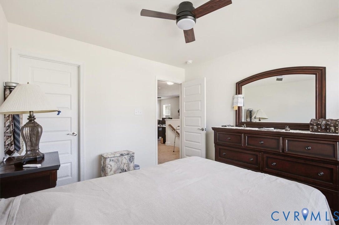 18743 Palisades Ridge, Palisades Cove, Moseley, VA 23120 Neutral-toned bedroom featuring three-panel interior doors, a central ceiling fan with integrated lighting, and carpeted flooring