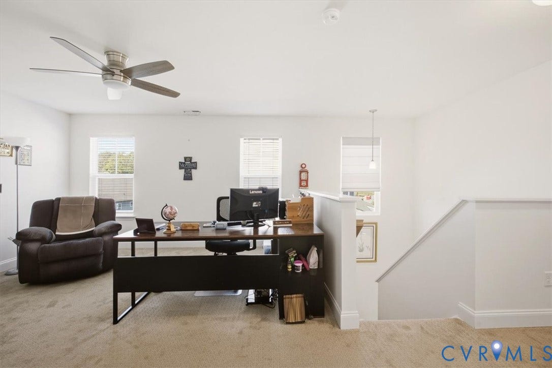 18743 Palisades Ridge, Palisades Cove, Moseley, VA 23120 Open floor plan featuring carpeting, three windows with blinds, a ceiling fan with integrated lighting, and a half-wall stair railing